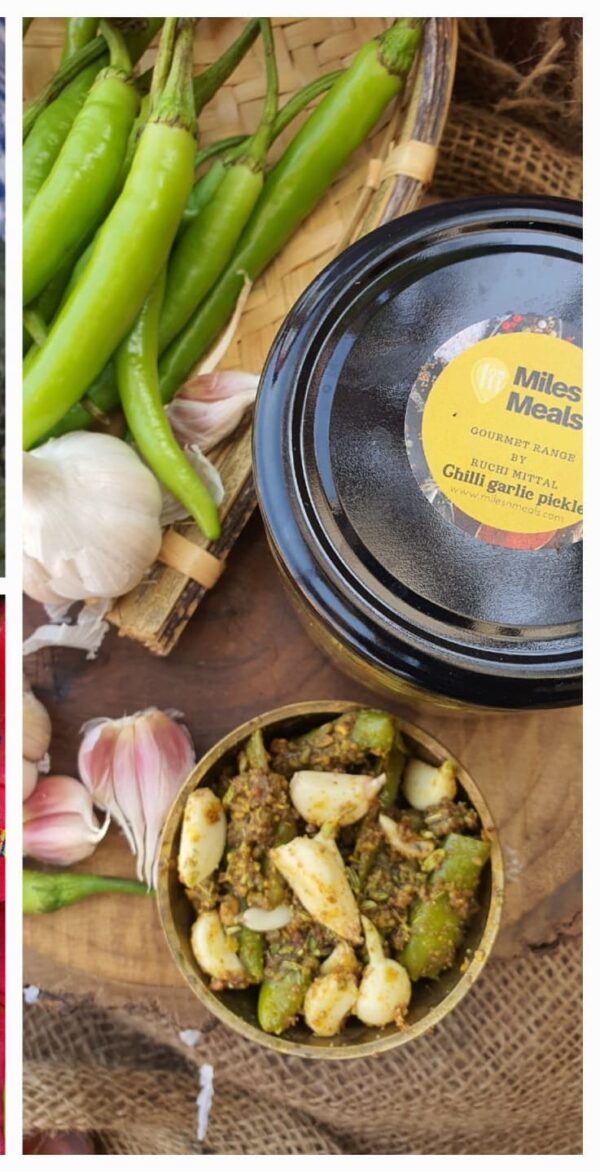 Enticing green Chilli Pickle in a bowl surrounded by green chilies and garlic